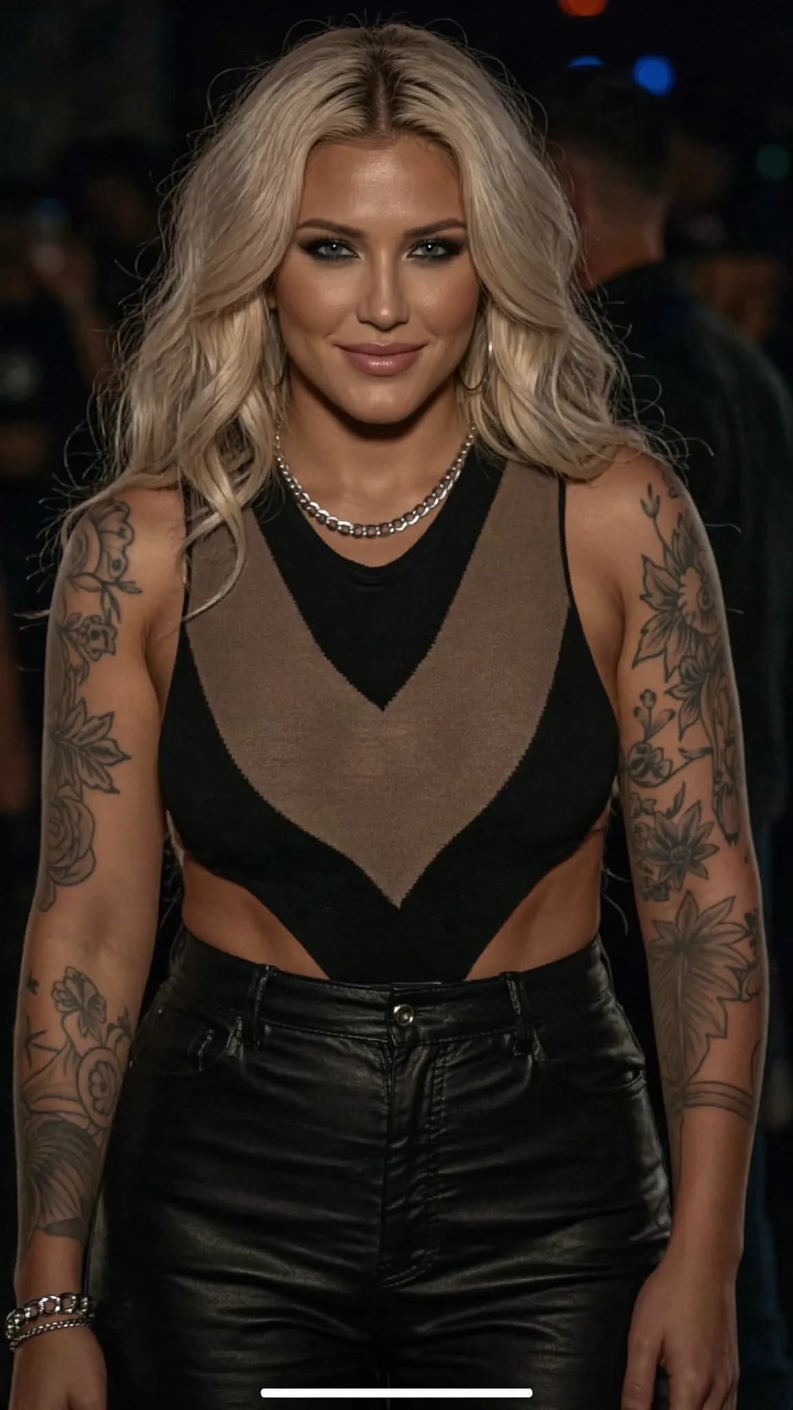 A woman with platinum blonde hair and tattoos stands confidently in an outdoor setting, wearing a casual outfit.