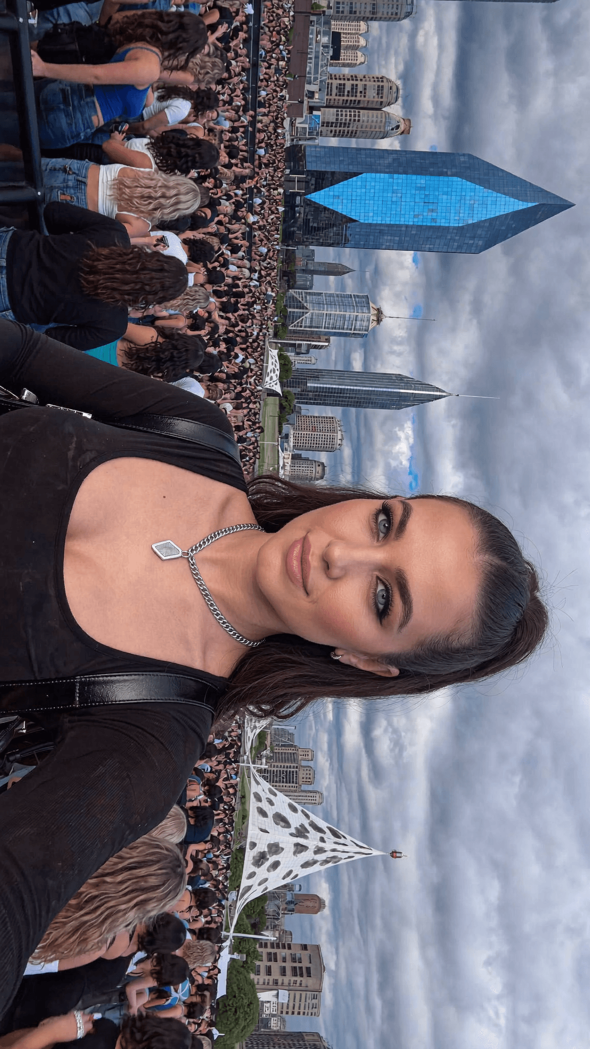 A woman with a pixie cut and septum ring poses for the camera at an outdoor event.