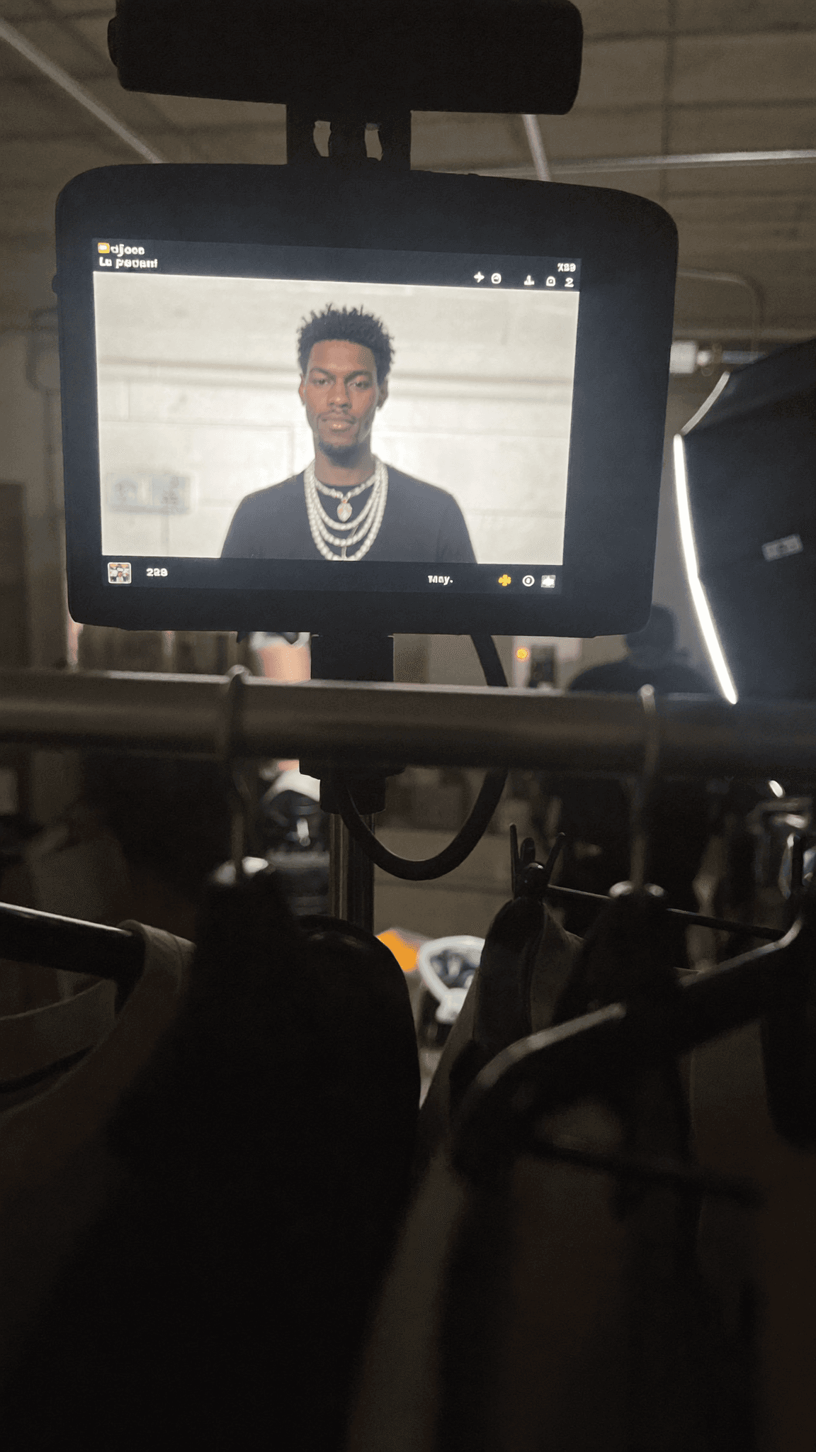 A person with a pixie cut and septum ring is being filmed in a studio setting.