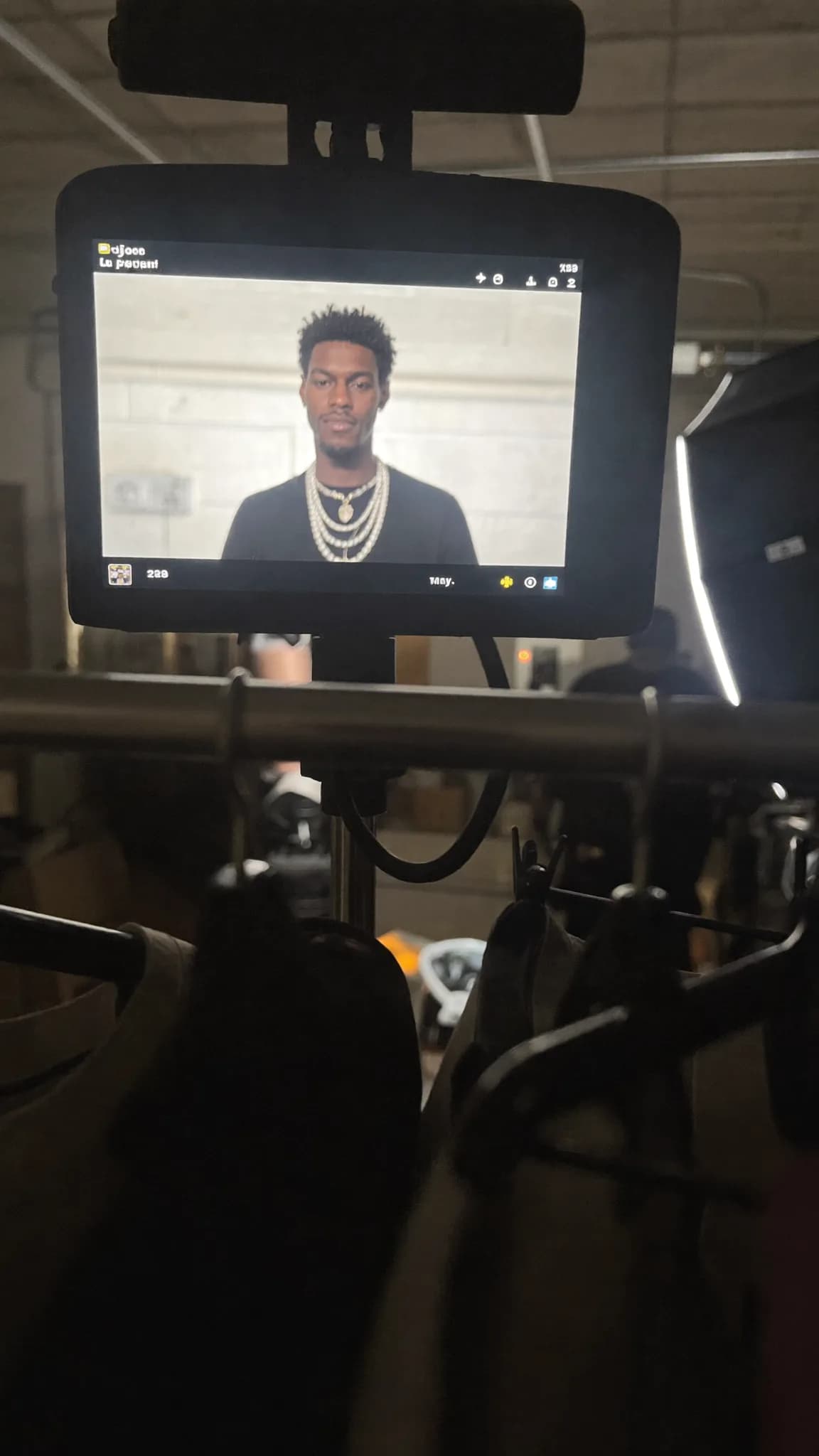 A person with a pixie cut and septum ring is being filmed in a studio setting.