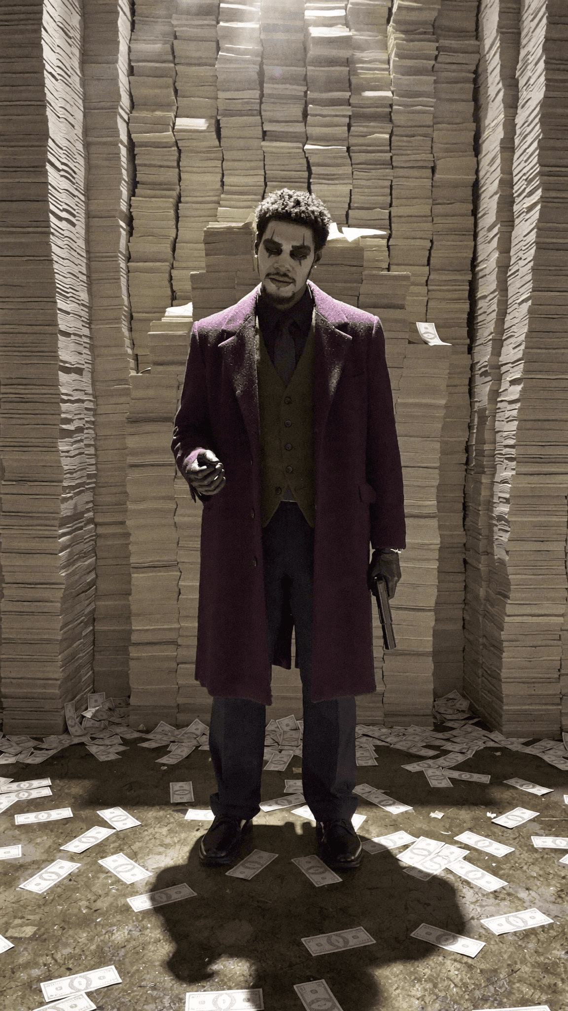 A character dressed as a villain stands amidst stacks of money, holding a gun.