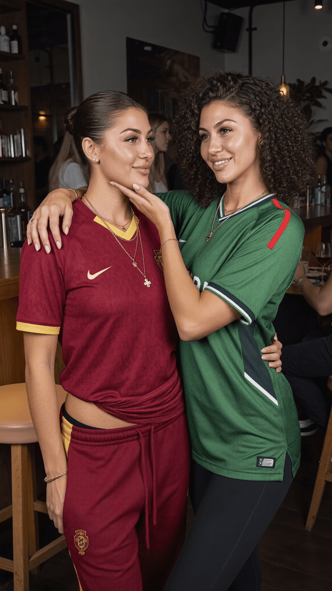 Two women in athletic wear pose playfully at a club.