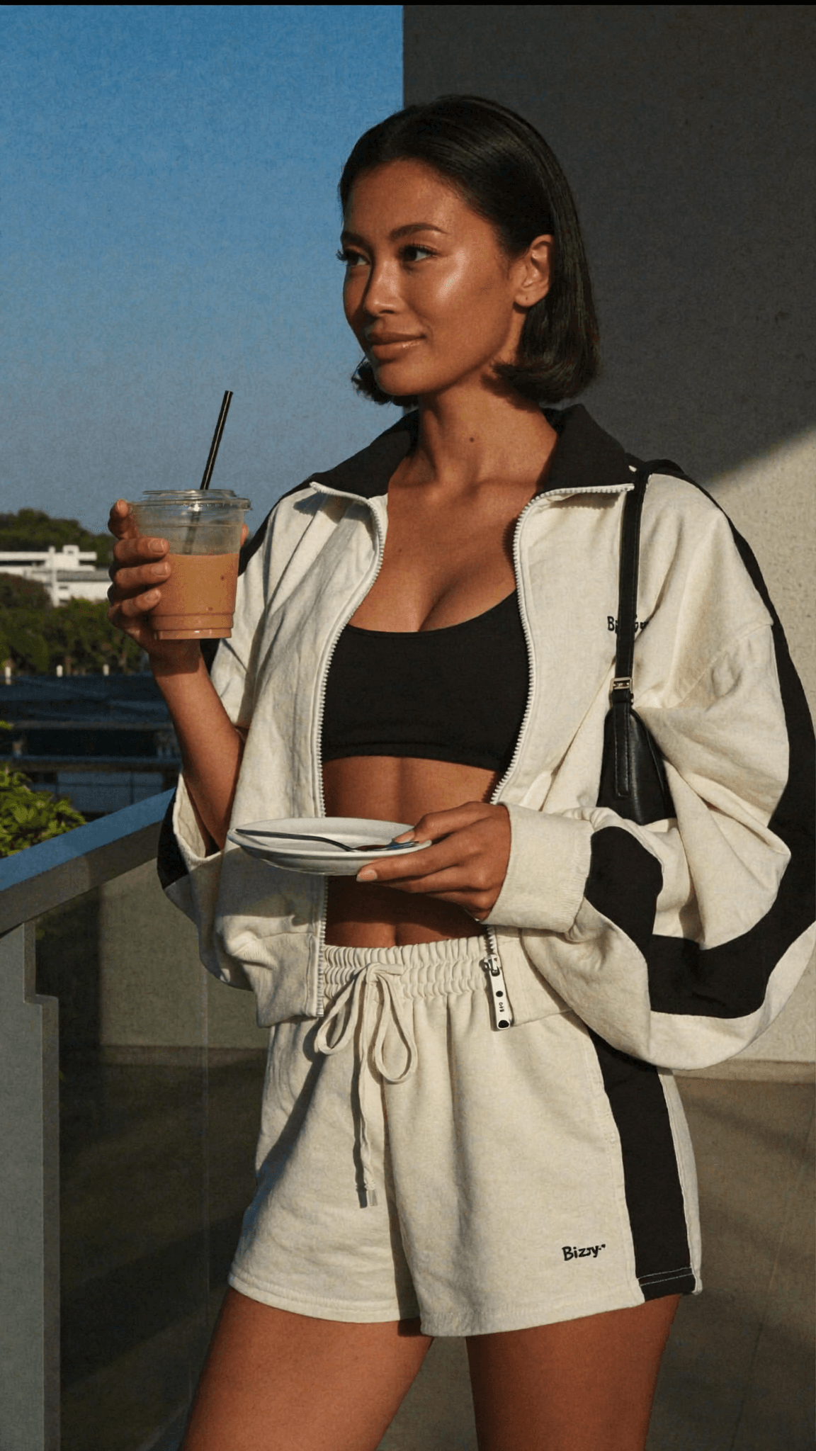 A woman in a dress stands outdoors, exuding confidence and allure.