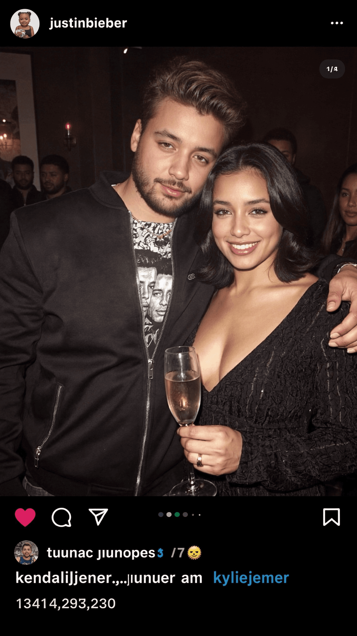 A couple poses together at a club, with the woman holding a champagne glass.